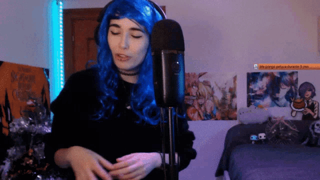 a woman in a blue wig is singing into a microphone