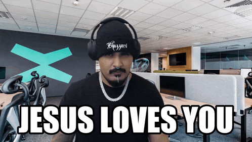 a man wearing headphones and a beanie says " jesus loves you "
