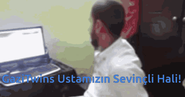 a man sits in front of a laptop with the words " gazi twins ustamizin sevingli hati " written below him