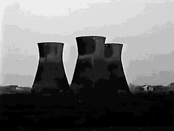 a black and white photo of three cooling towers at a power plant