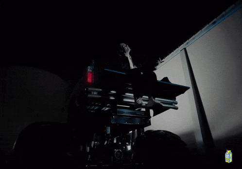 a man sits on the back of a truck with a bottle of lychee juice in the background