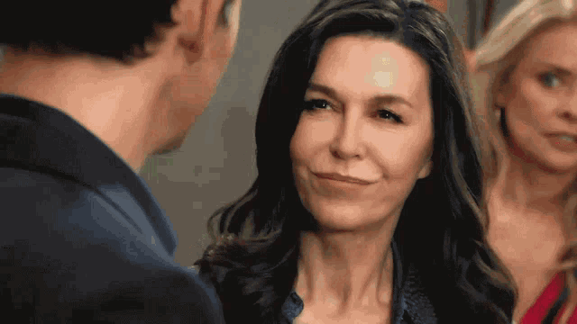 a woman is smiling while looking at a man