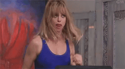 a woman in a blue tank top is walking on a treadmill .