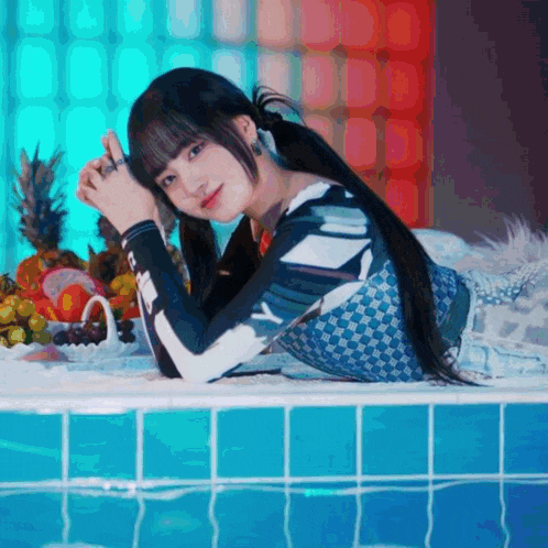 a woman is laying in a bathtub with a bowl of fruit behind her