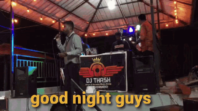 a man singing into a microphone with a dj thrash sign behind him