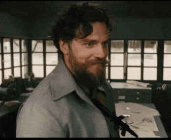 a man with a beard wearing a grey shirt