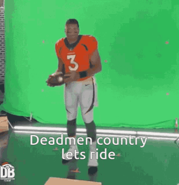 a man in an orange jersey with the number 3 on it is holding a football .