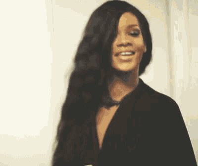 a woman with long black hair and a black jacket smiles