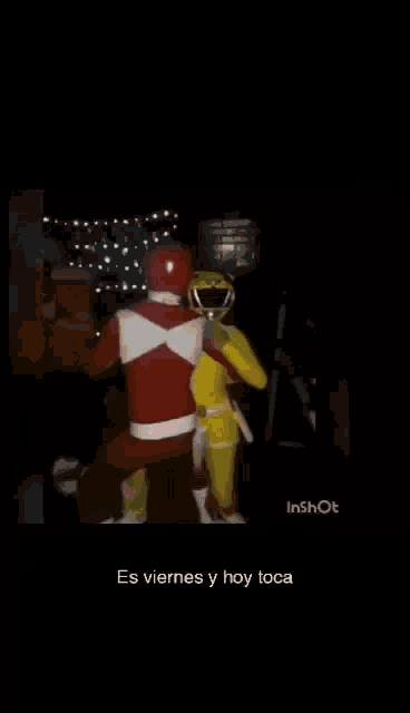 a couple of power rangers are hugging each other in a dark room .