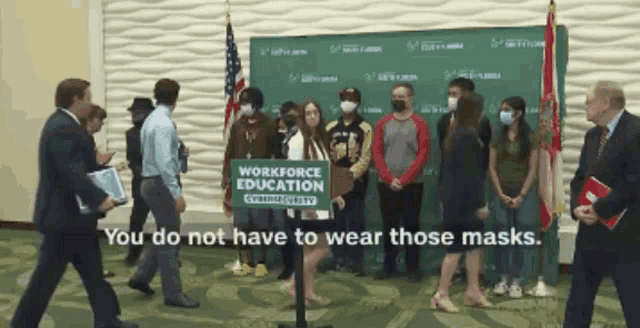 a group of people standing around a sign that says " workforce education "