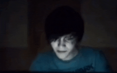 a blurry picture of a person in a blue shirt in the dark