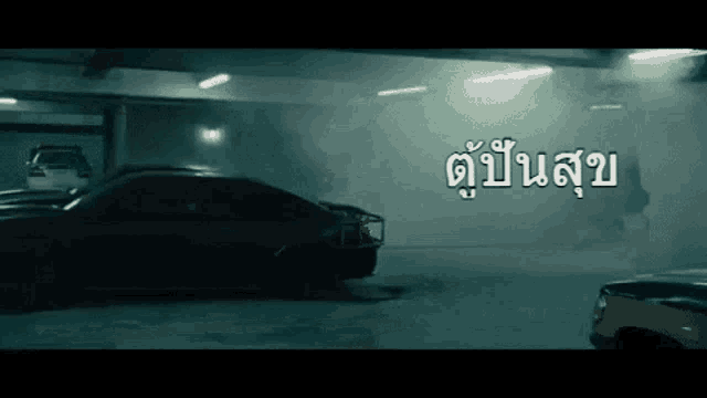 a car is parked in a parking garage with a foreign language written on the bottom right