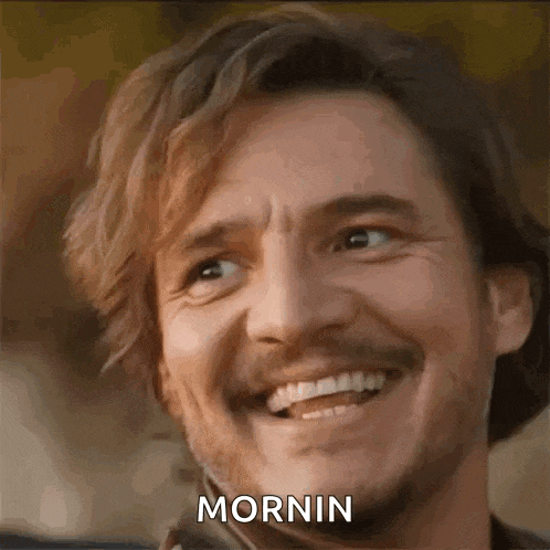 a man with a beard and mustache is smiling with the word mornin on his face .