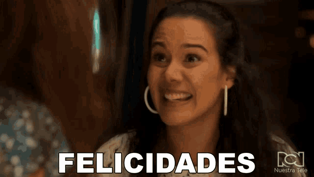 a woman with hoop earrings is smiling with the word felicidades above her