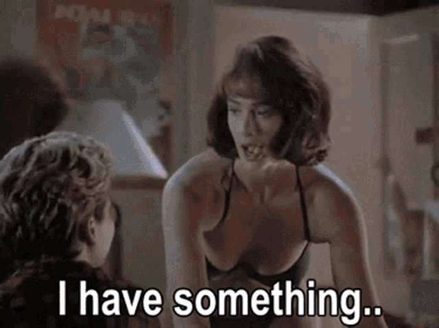 a woman in a bra is talking to a man and says i have something
