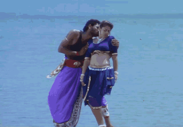 a man and a woman standing next to each other on a beach