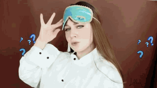 a woman wearing a sleep mask and a white shirt with question marks around her