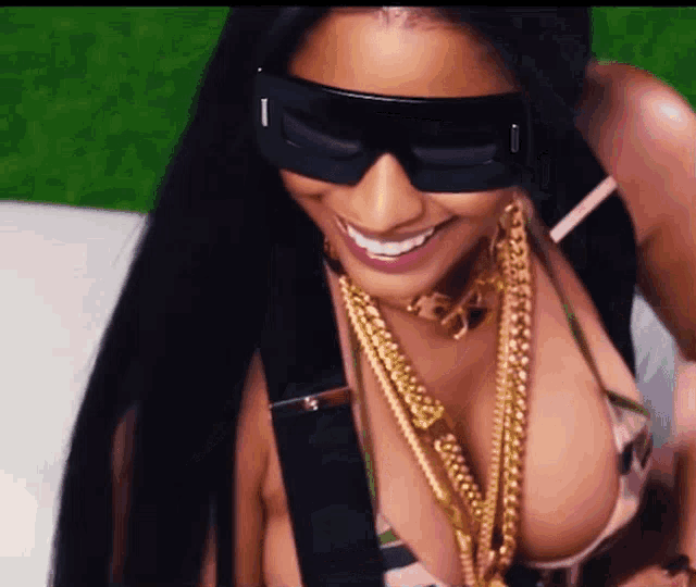 a woman wearing sunglasses and a necklace with the letter i on it