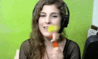 a woman wearing headphones is holding a yellow object