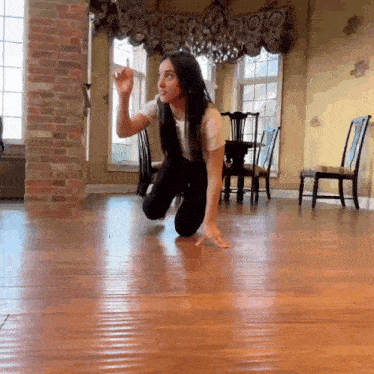 a woman is kneeling down on the floor in a room