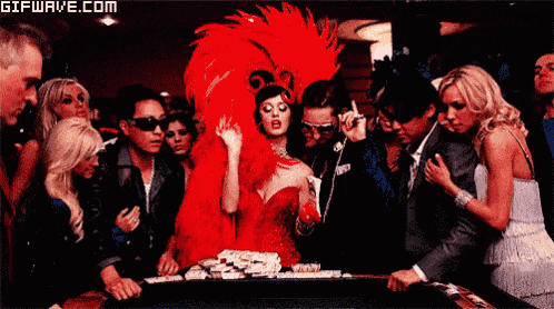 a woman in a red dress stands in front of a poker table with a gifwave.com watermark on the bottom