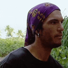 a man wearing a purple head scarf and earrings