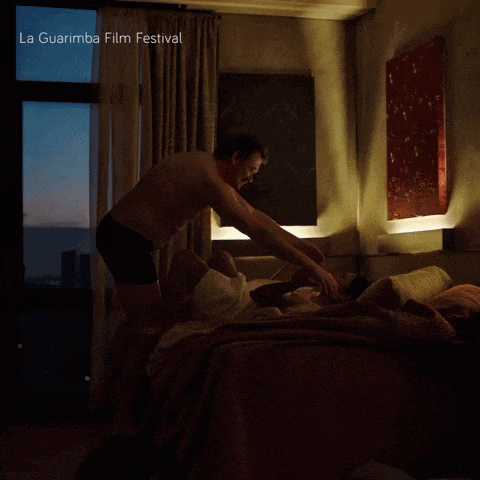 a poster for la guarimba film festival shows a man laying on a woman on a bed