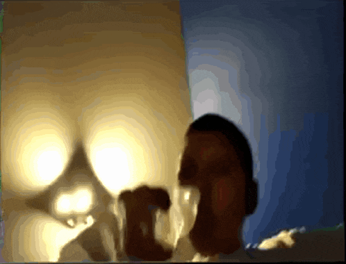 a blurry picture of a man 's face with a light behind him
