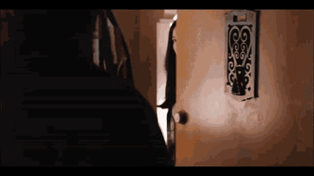 a woman stands in front of a door with a swirl design