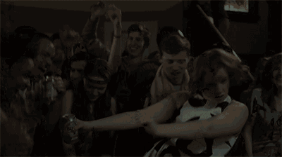 a group of people are dancing in a dark room and one of them is wearing a shirt that says daa