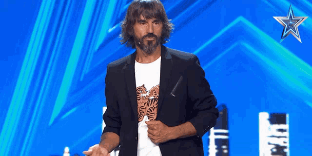 a man with long hair and a beard stands on a stage