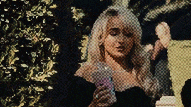 a woman in a black top is holding a pink cup