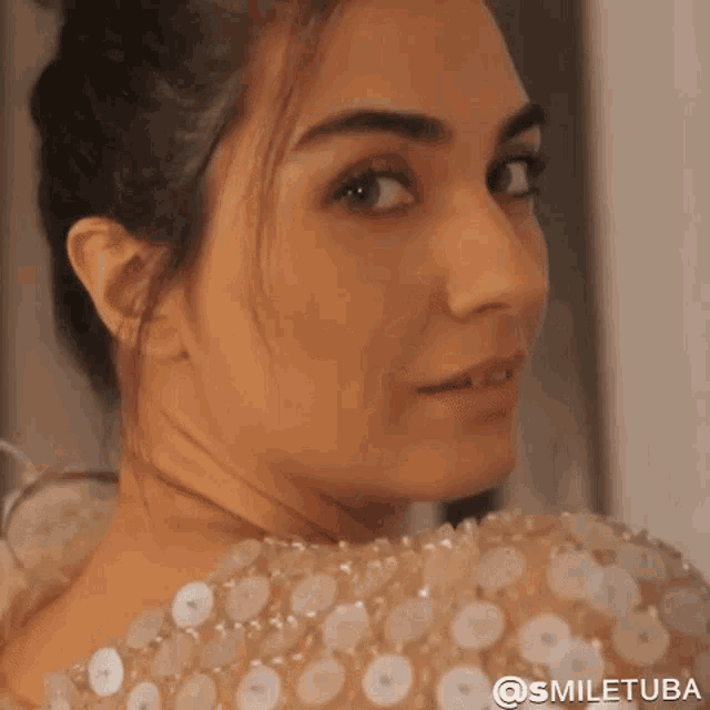 a close up of a woman 's face with the words smiletuba on the bottom right
