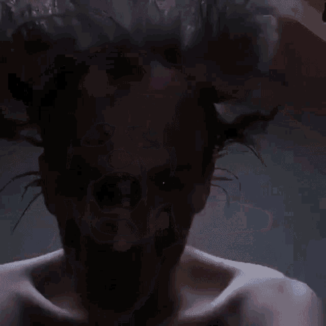a man with a beard is holding his head with his hands .