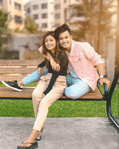 a man and a woman are sitting on a wooden bench