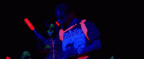 a man in a glow in the dark shirt is standing in front of a microphone .