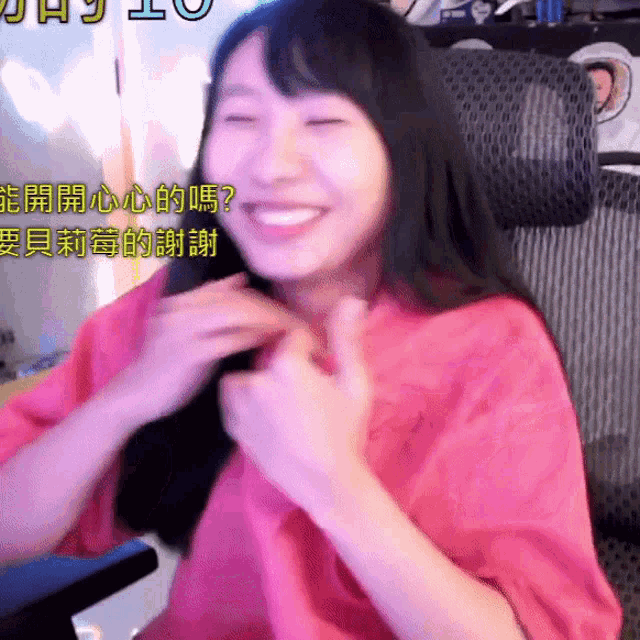a woman in a pink shirt is smiling with chinese writing on the bottom right