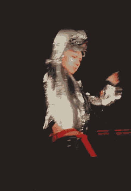 a blurred image of a person in a silver jacket