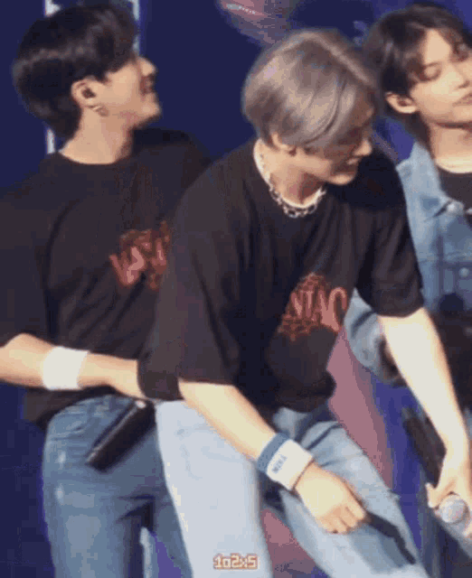 a man wearing a black shirt that says niao is being held by another man