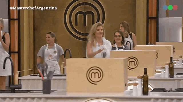 a group of women are standing in front of a masterchef sign