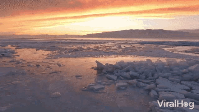 a sunset over a body of water with viralhog written on the bottom right