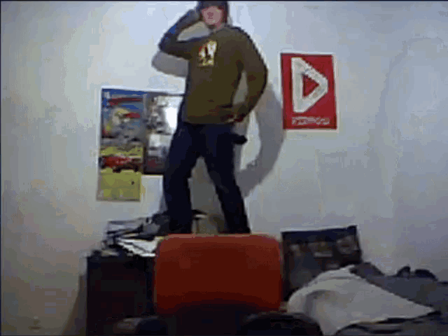a man is standing on a chair in front of a wall that has a red sign that says ' arrow '