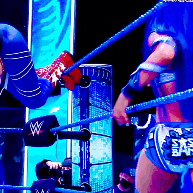 a woman in a wrestling ring is wearing a belt that says sasha banks on it