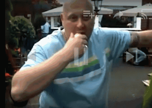 a man in a blue shirt is holding a microphone