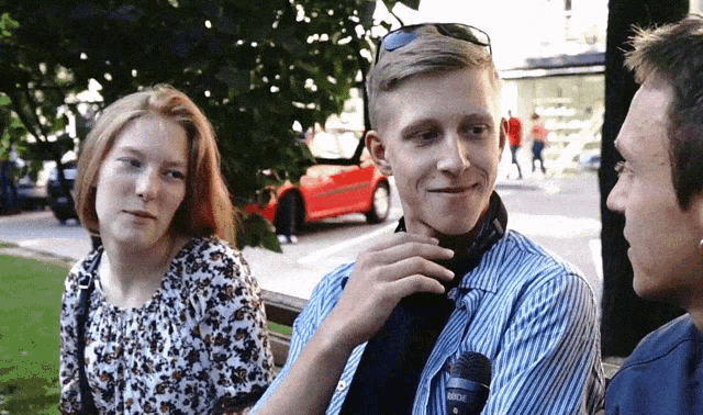 a man with a rode microphone in his pocket talks to a woman