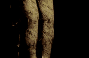 a statue of a woman is standing in a dark room holding a bird .