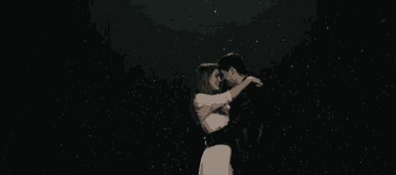 a man and a woman are kissing in the rain .