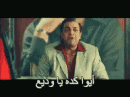 a man in a suit with arabic writing on the screen