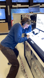 a man wearing headphones is standing in front of a display of beats studio pro headphones