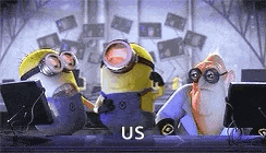 a group of minions are sitting at a desk in front of computers .